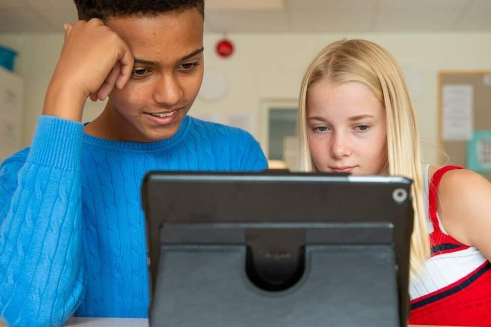 En pojke och en flicka tittar på en dator