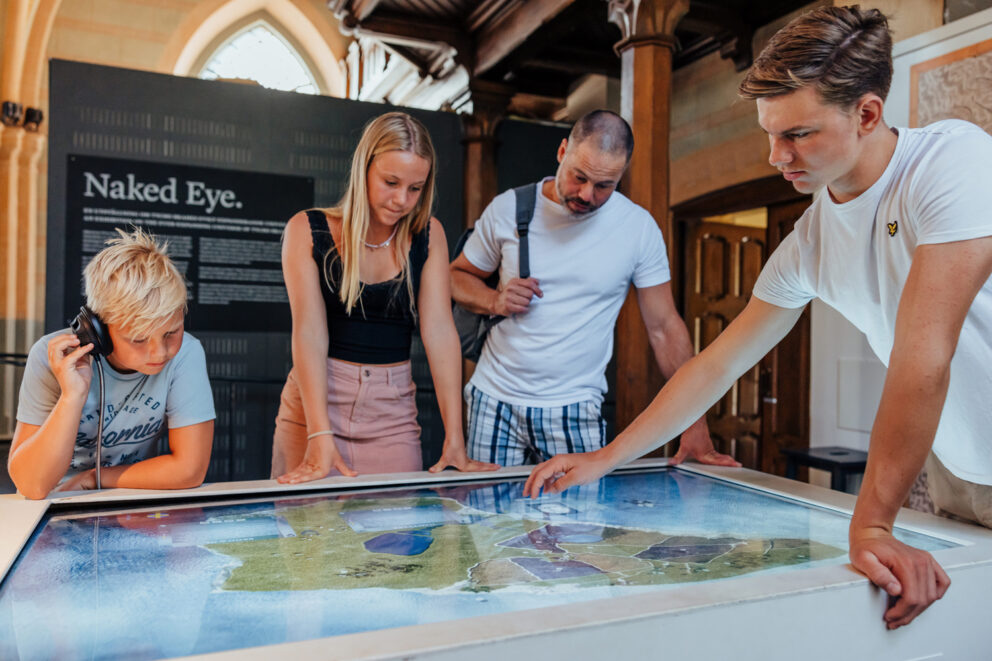 Fyra personer står och tittar på utställningen på Tycho Brahe-museet