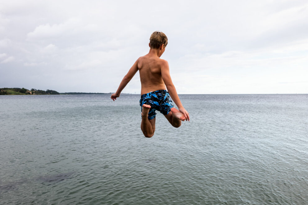 En pojke hoppar ut i havet