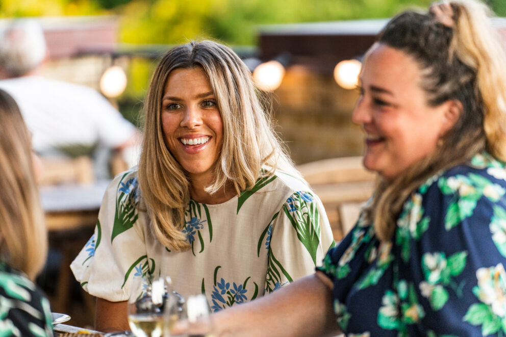 Två kvinnor sitter och pratar på en restaurang