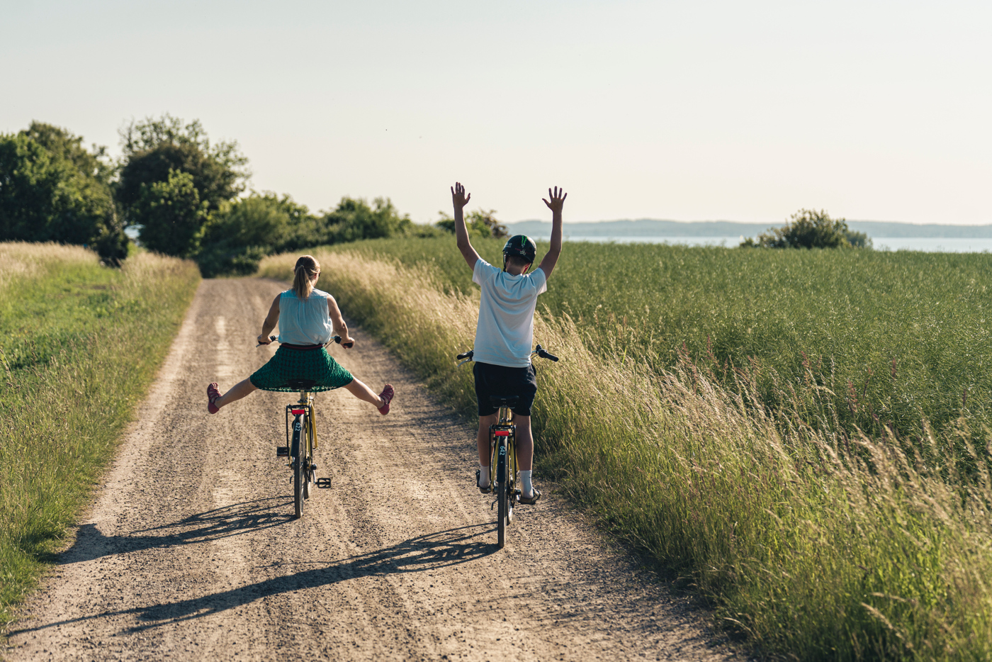 Två personer cyklar på en grusväg