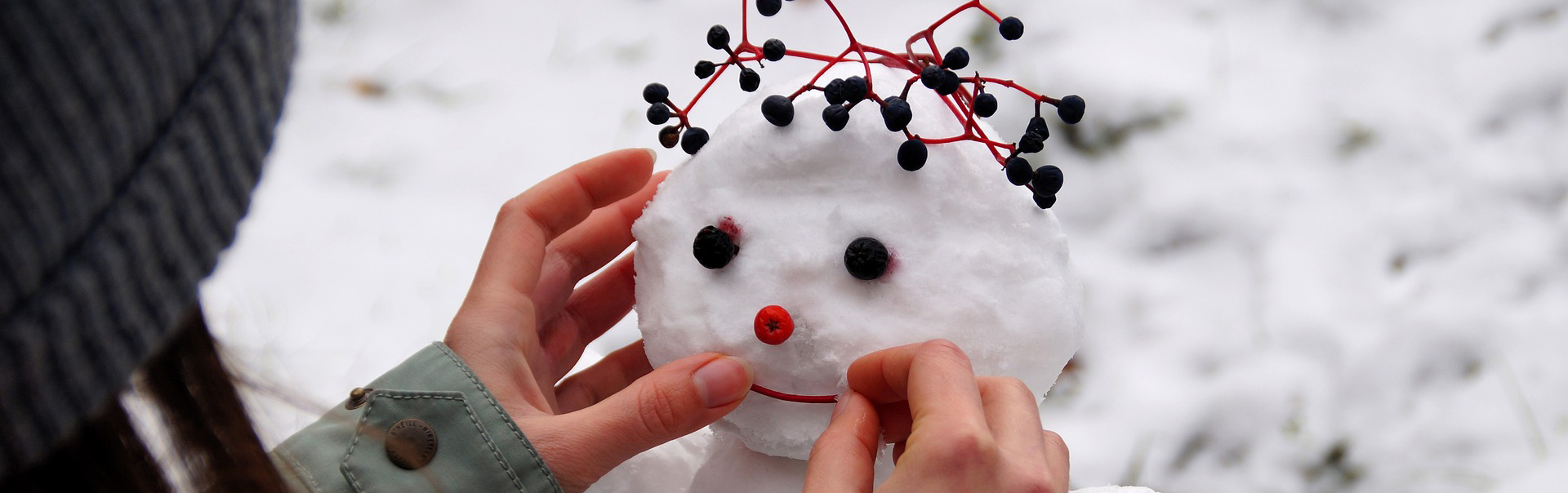 Ett barn dekorerar en snögubbe