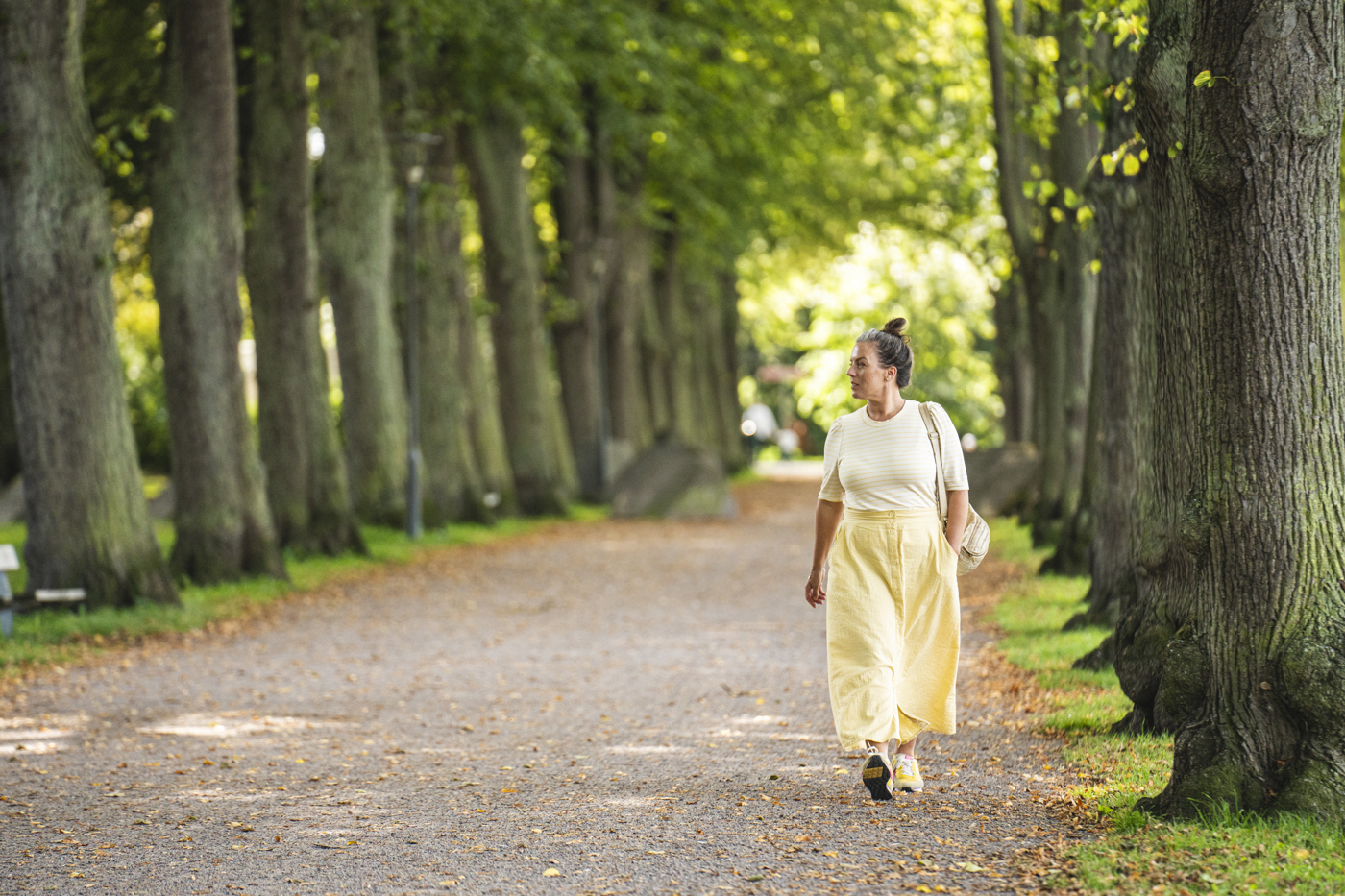 En kvinna promenerar i Slottsparken
