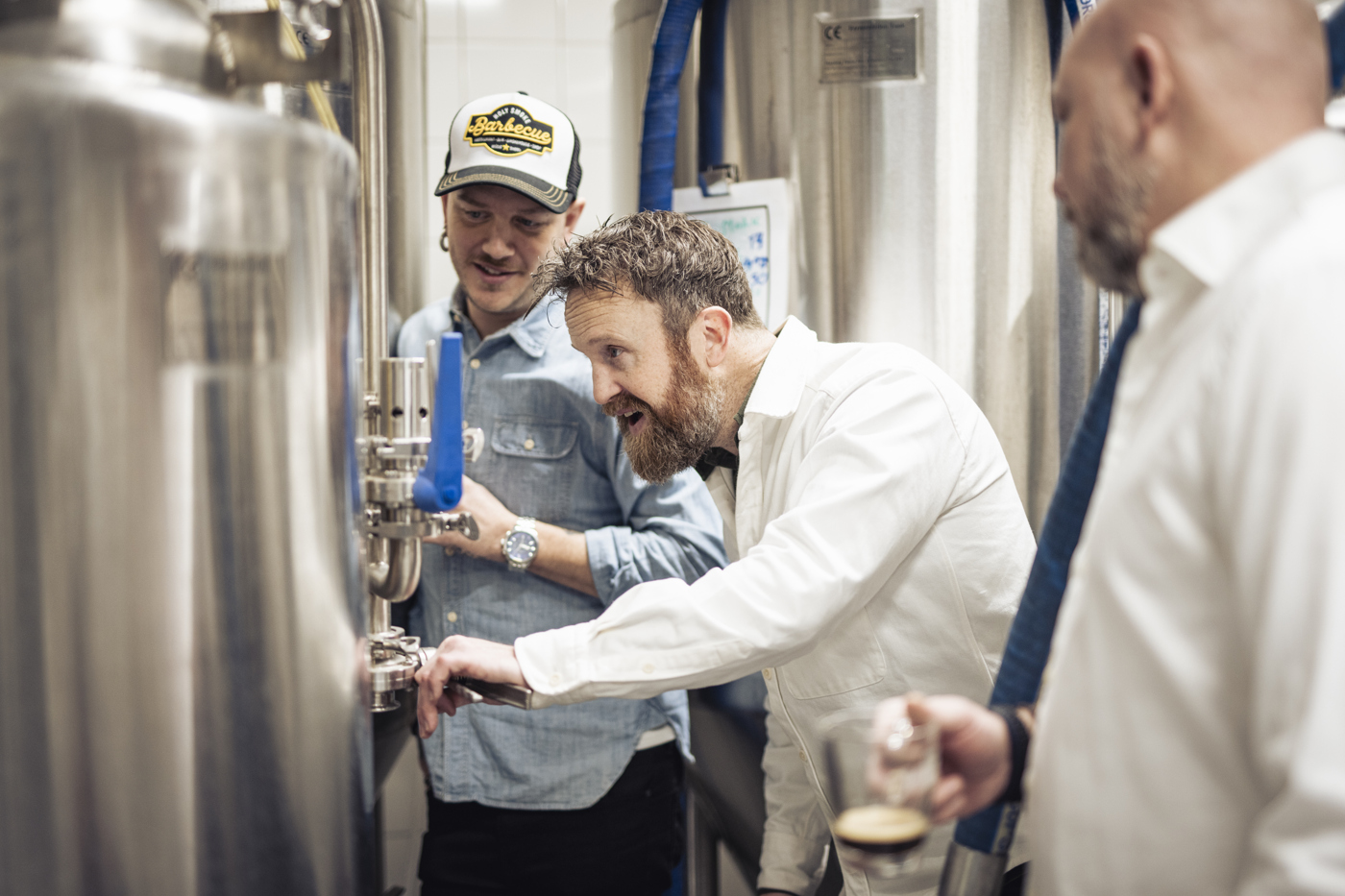 Tre män står inne på ett ölbryggeri