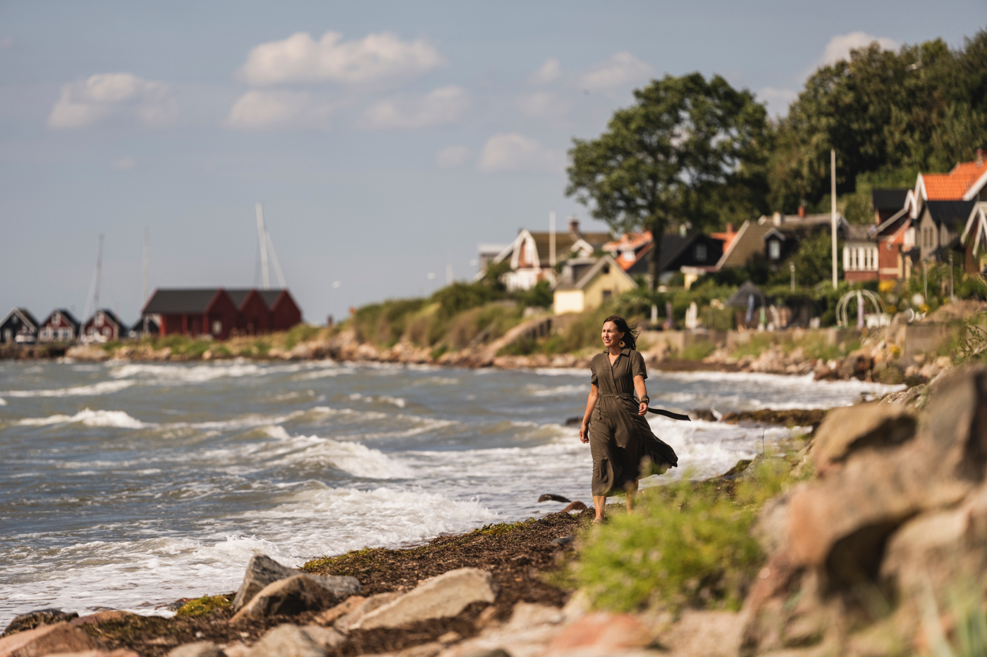 En kvinna gå längs stranden på Ven