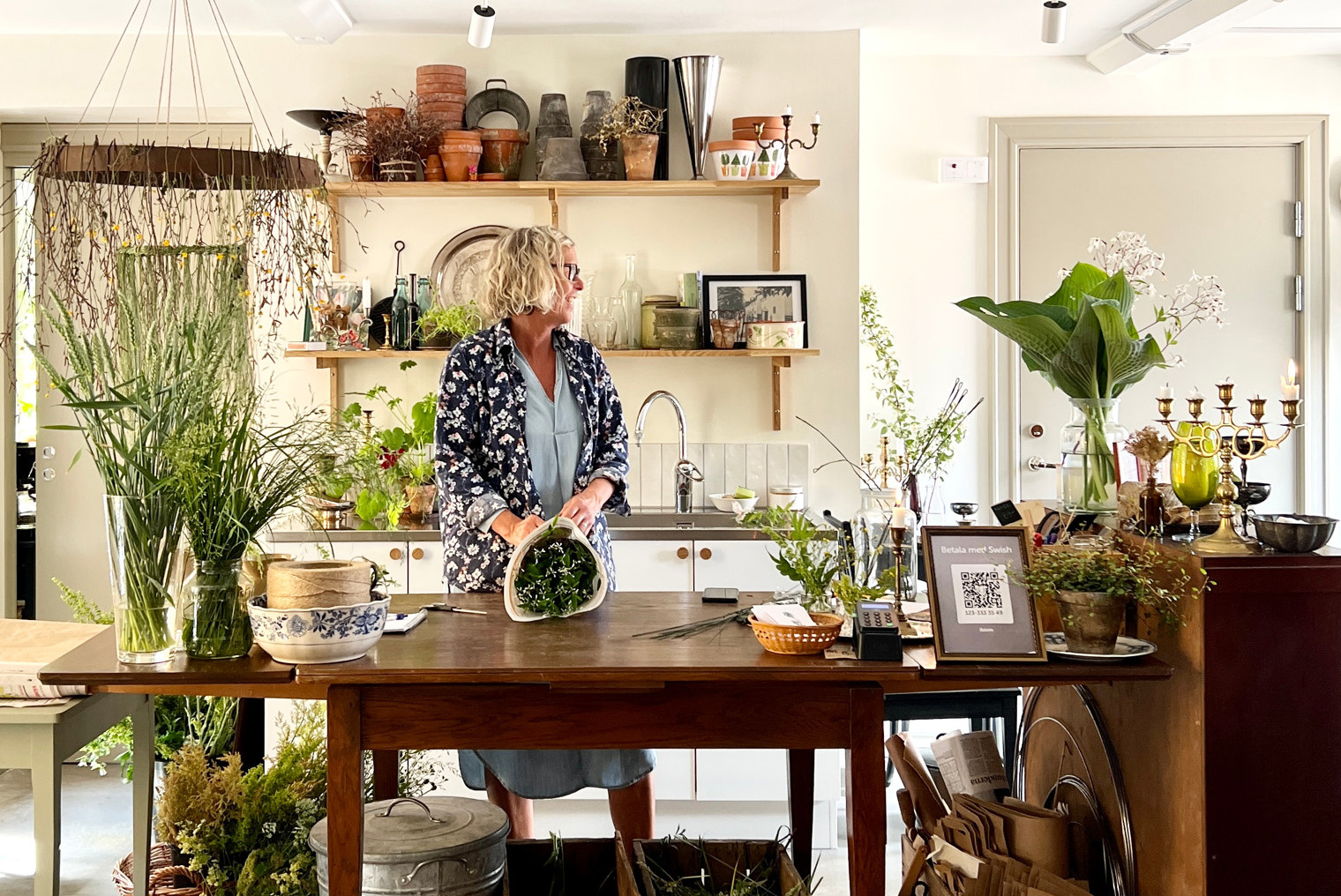 en kvinna står vid disken i en butik