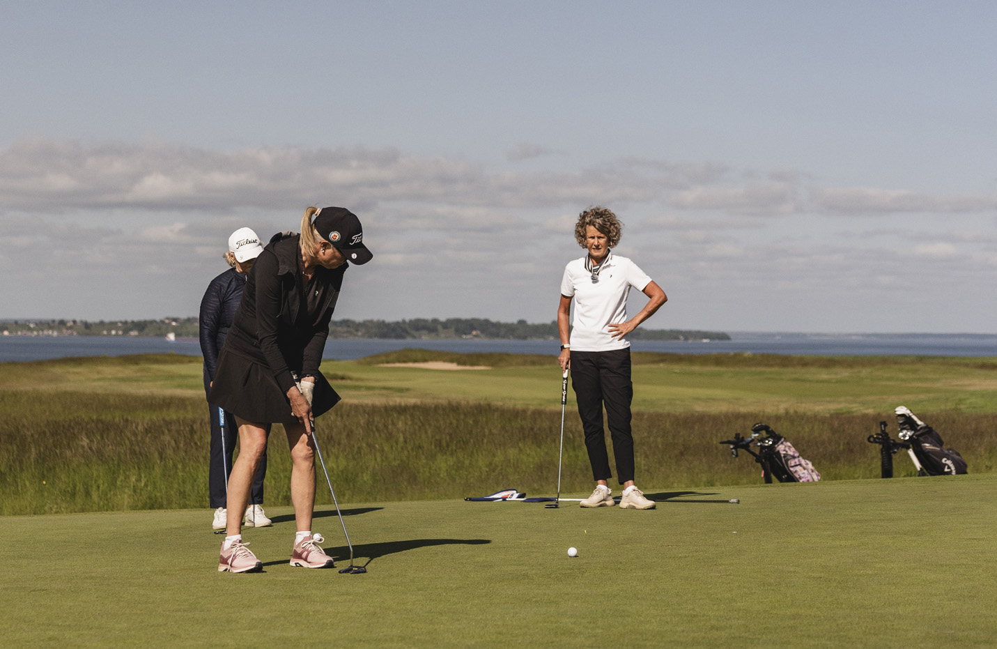 Tre kvinnor spelar golf
