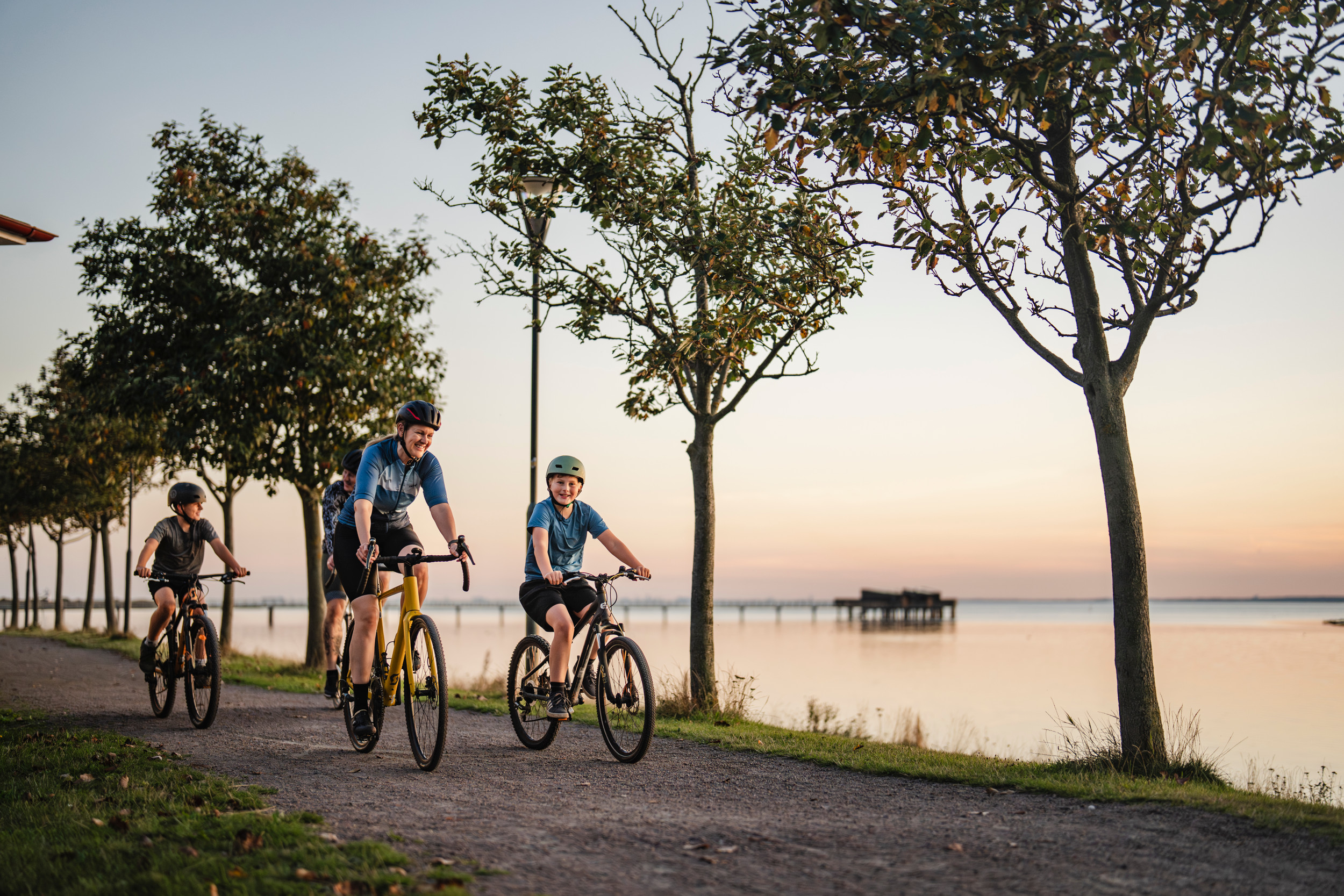 Fyra personer cyklar längs havet