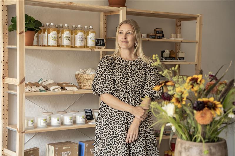 Louise står framför en hylla med produkter