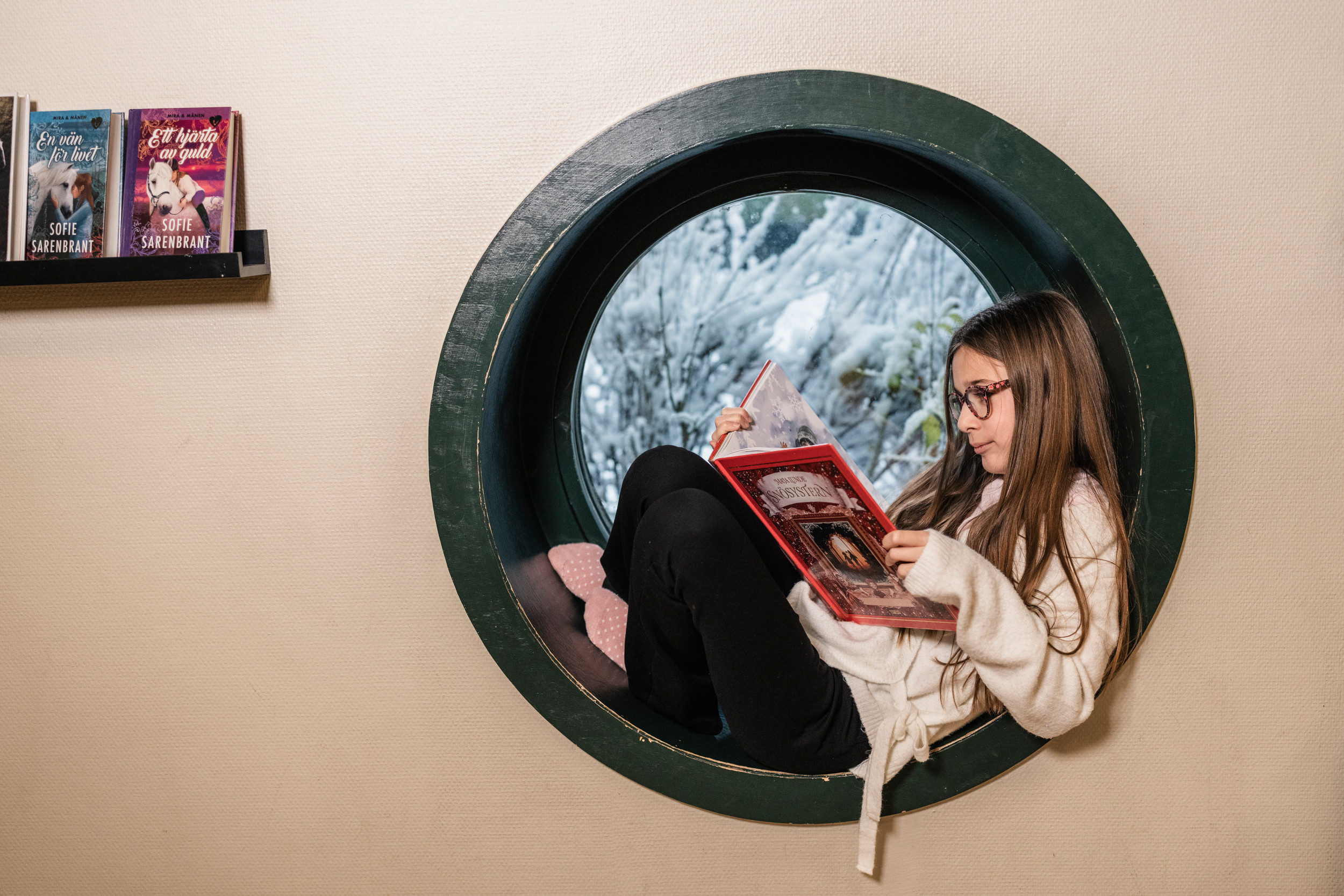En kvinna sitter och läser bok för två barn