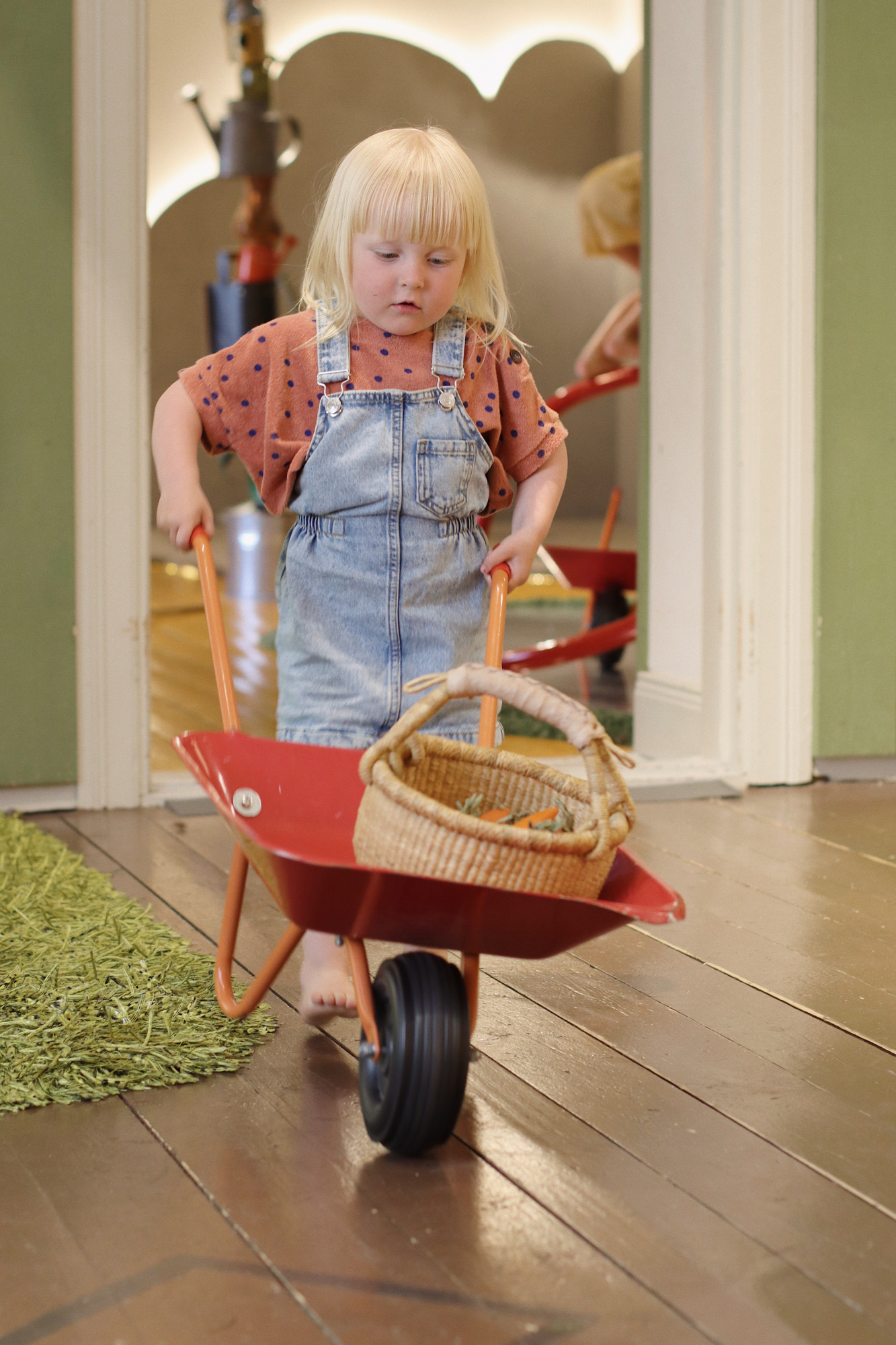 En liten flicka kör skottkärra